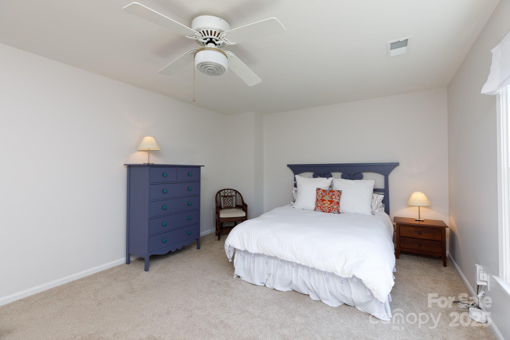 2815 Providence Spring Lane Charlotte, NC 28270 - Photo 21 of 42 a bedroom with a bed and a chandelier