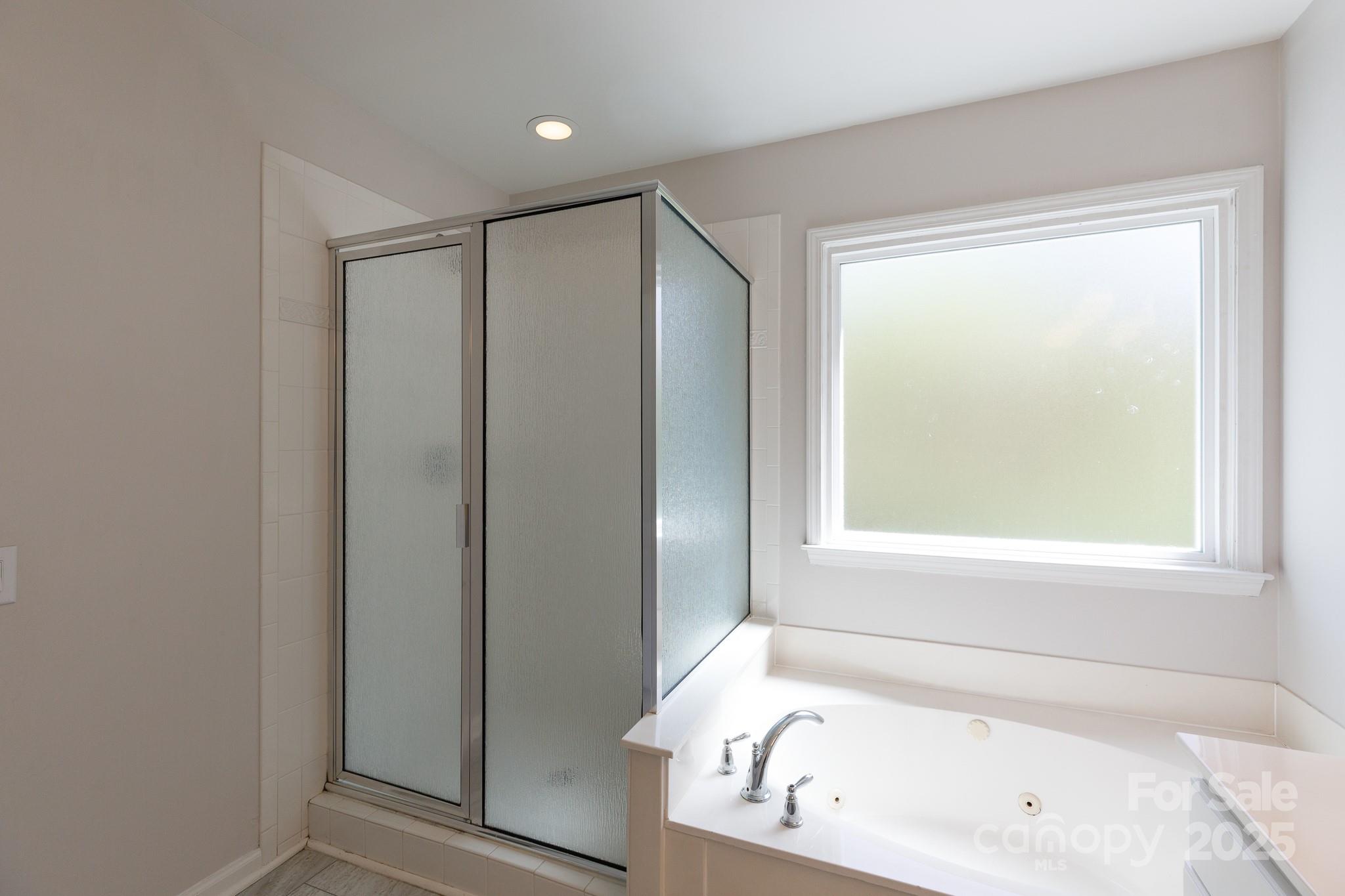 2815 Providence Spring Lane Charlotte, NC 28270 - Photo 24 of 42 a white bath tub sitting in a bathroom next to a window