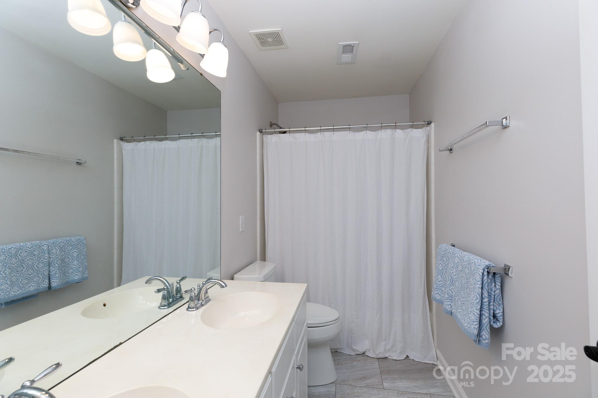 2815 Providence Spring Lane Charlotte, NC 28270 - Photo 30 of 42 a bathroom with a sink a toilet and mirror