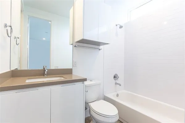 a bathroom with a granite countertop sink toilet and shower