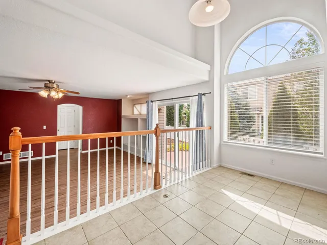 an empty room with a window and a ceiling fan