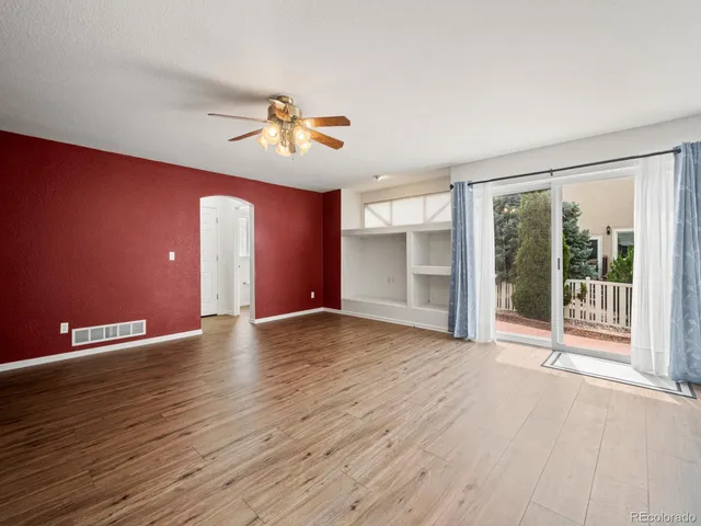 an empty room with ceiling fan and window