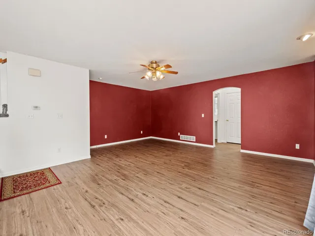 an empty room with windows and fan