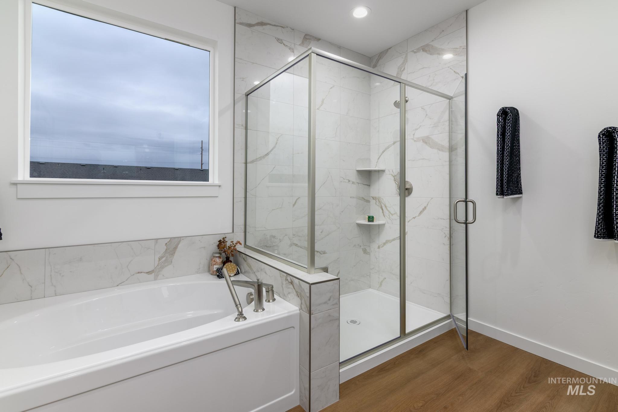 2087 West Gelding Street Middleton, ID 83644 - Photo 22 of 41 Full bath featuring a bath, dark wood finished floors, and a marble finish shower