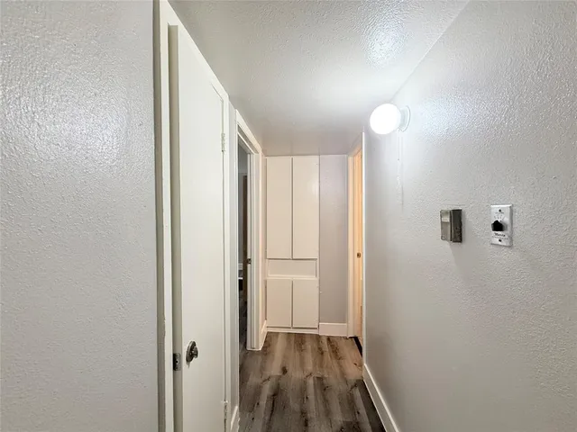 a view of a hallway with wooden floor and closet