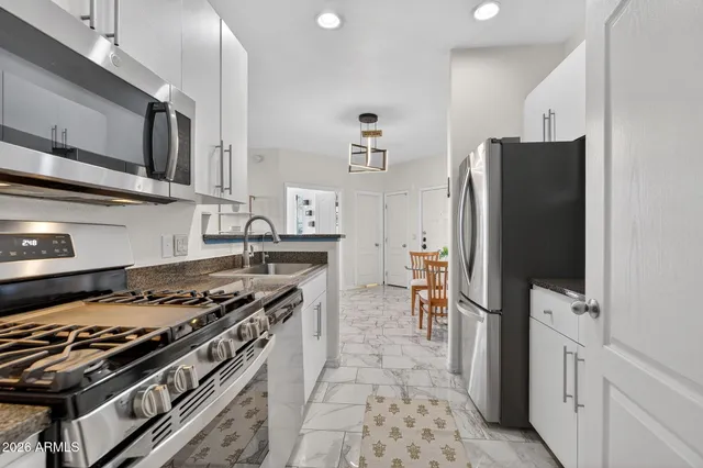 a kitchen with stainless steel appliances granite countertop a stove and a refrigerator
