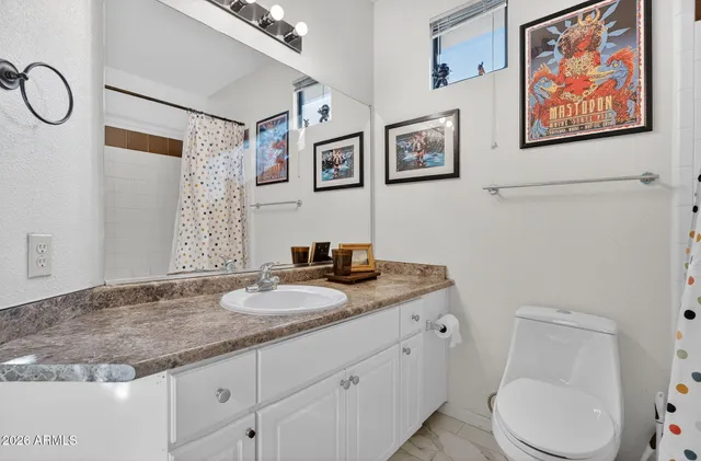 a bathroom with a granite countertop sink mirror vanity and toilet