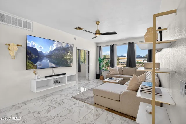 a living room with furniture a flat screen tv and a floor to ceiling window