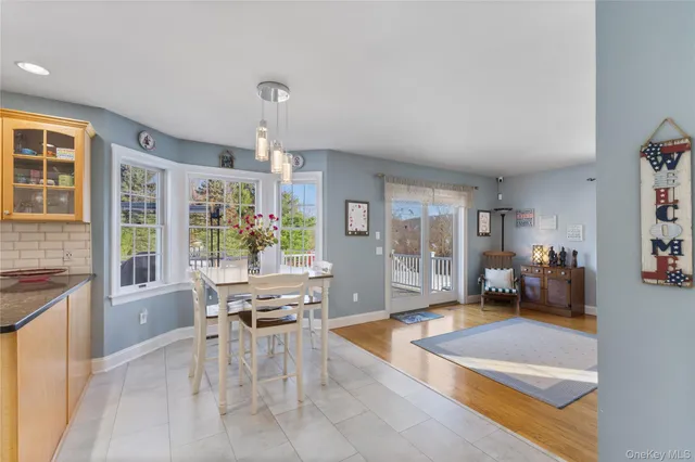 a dining hall with stainless steel appliances granite countertop a refrigerator and a view of living room