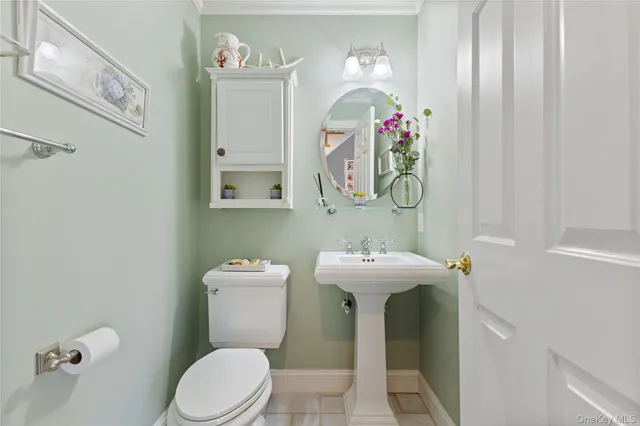 a view of a hallway with wooden floor and a bathroom