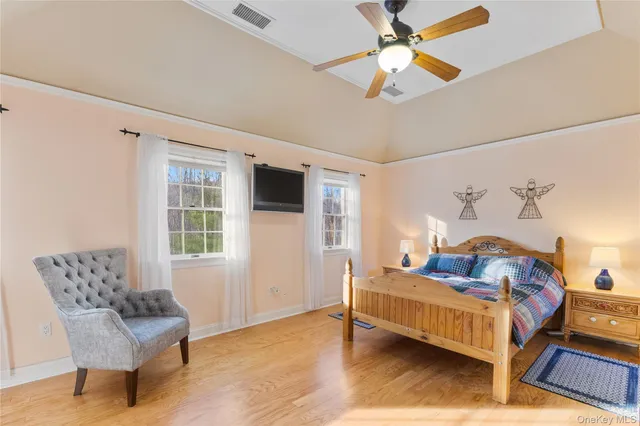 a bathroom with double vanity sinks a large mirror and a bathtub next to a window