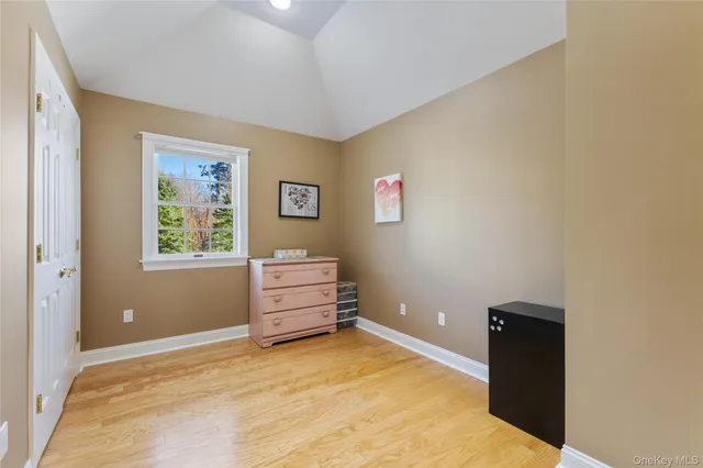 a bedroom with a bed wooden floor and window