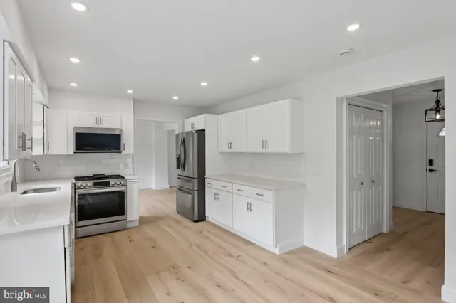 a kitchen with white cabinets and stainless steel appliances