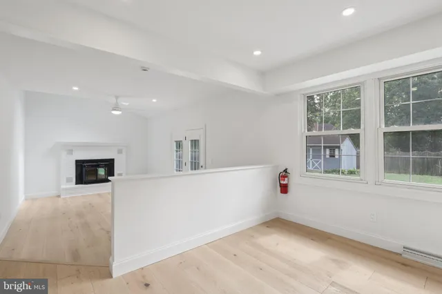 an empty room with windows and fireplace