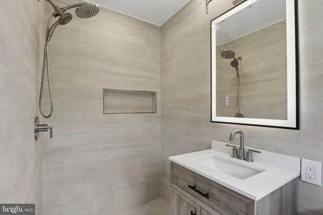 a bathroom with a toilet a sink a mirror and a window