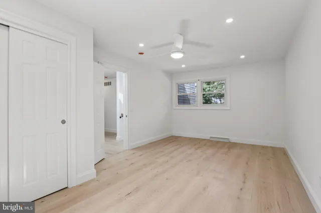 an empty room with a window and a fan
