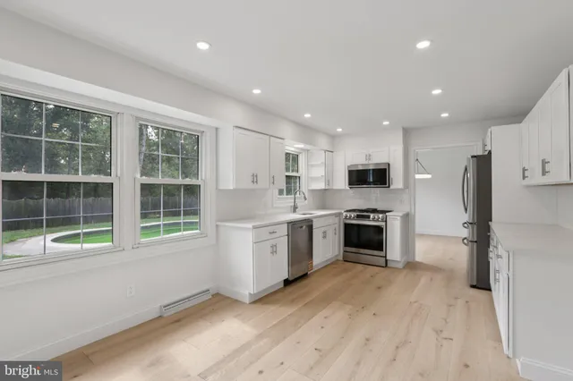 a large kitchen with a large window and stainless steel appliances