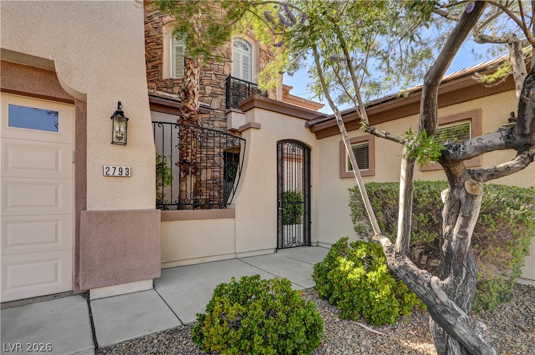 2793 Rosenhearty Drive Henderson, NV 89044 - Photo 70 of 85 The welcoming entryway features a classic lantern and an ornate wrought iron gate, providing a charming and secure facade.