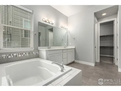 a bathroom with a bathtub a mirror and a sink