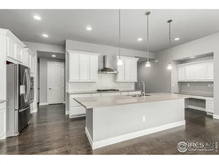 a large kitchen with a large counter top appliances and cabinets