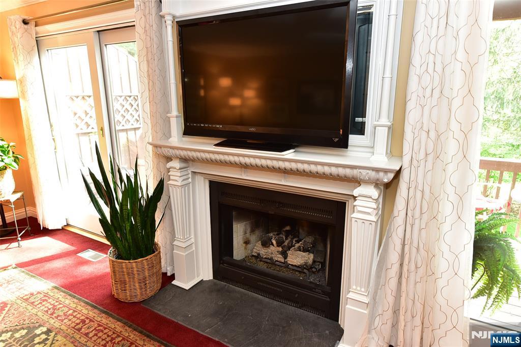 41 Litchult Lane Mahwah, NJ 07430 - Photo 15 of 50 a living room with a fireplace and a flat screen tv