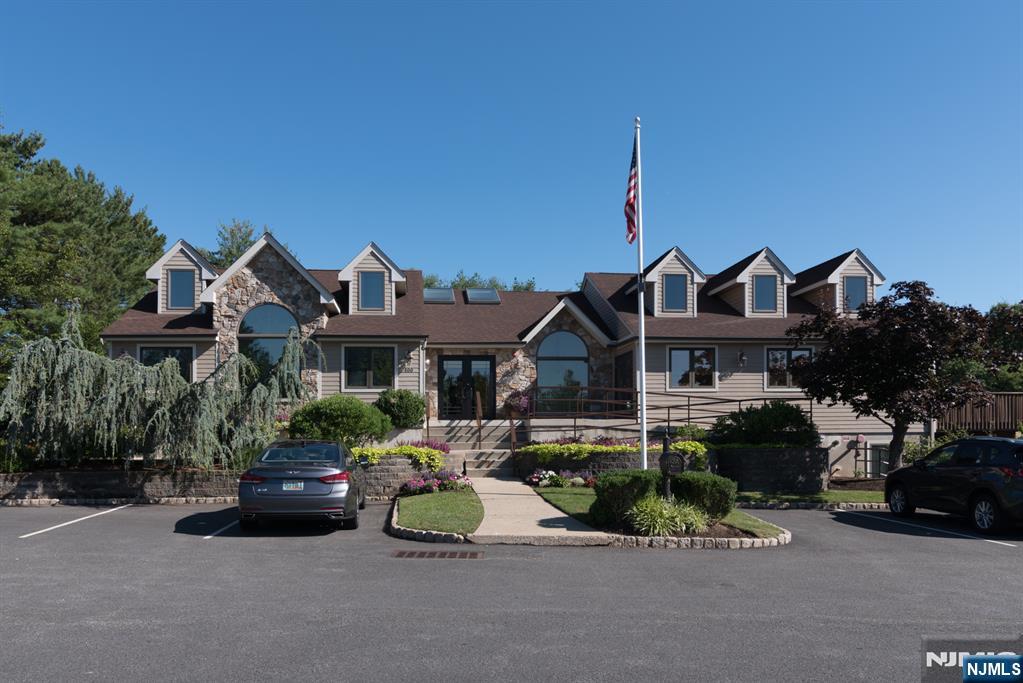 41 Litchult Lane Mahwah, NJ 07430 - Photo 39 of 50 a front view of a house with a garden and parking space