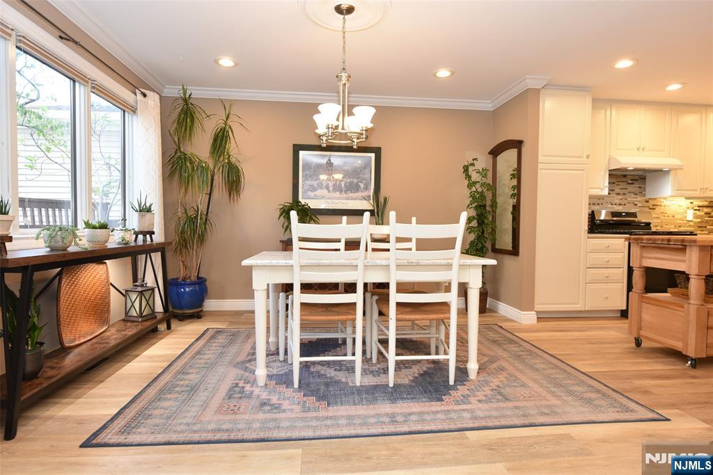 41 Litchult Lane Mahwah, NJ 07430 - Photo 7 of 50 a dining room with wooden floor a chandelier a glass table and chairs