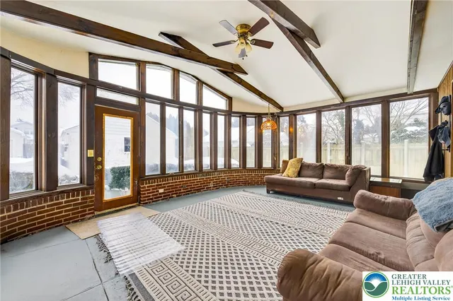 a living room with furniture and large windows