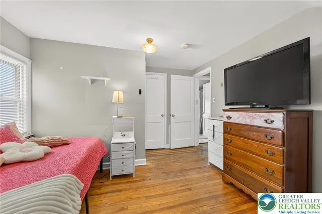 a bedroom with a bed and flat screen tv