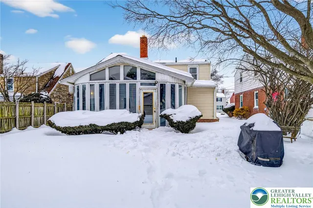 a view of a house with a yard covered in snow