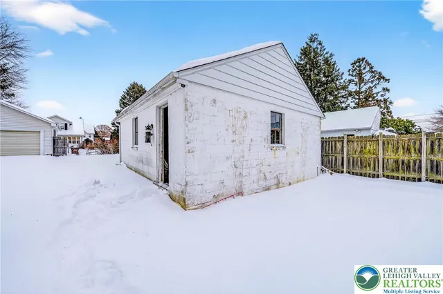 a view of a house with a wooden fence
