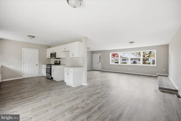a view of a kitchen with wooden floor and electronic appliances