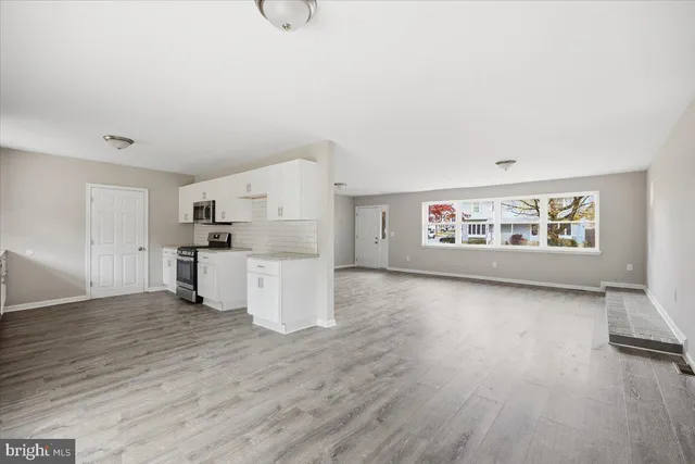 a view of a kitchen with wooden floor and electronic appliances
