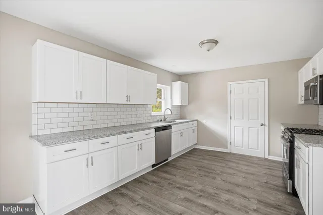 a kitchen with granite countertop white cabinets and white appliances