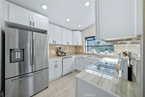a kitchen with granite countertop stainless steel appliances and wooden cabinets
