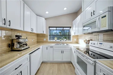 a kitchen with a sink a stove and cabinets