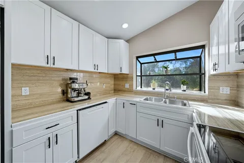a kitchen with a sink cabinets and window