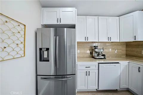 a kitchen with stainless steel appliances white cabinets and a refrigerator