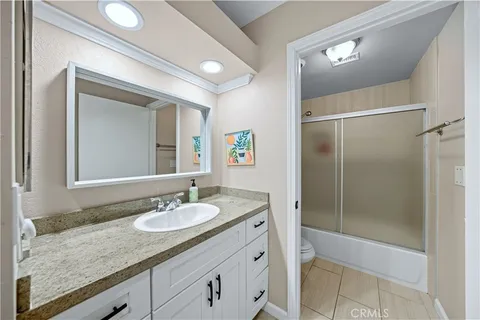 a bathroom with a granite countertop sink mirror and shower