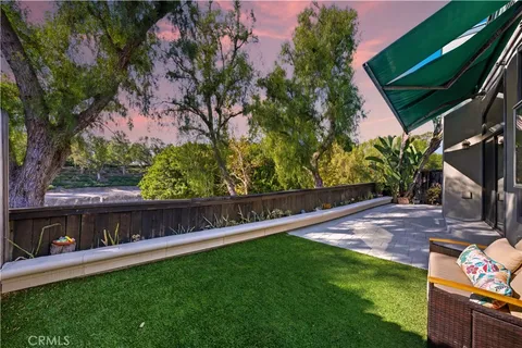 a view of backyard with a tub and wooden fence