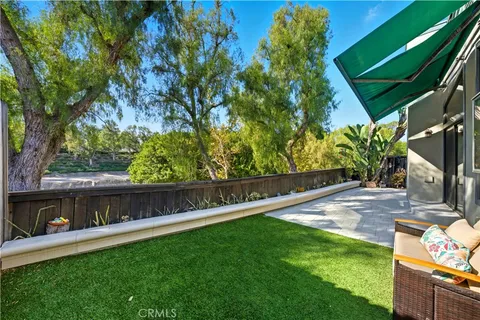 a view of backyard with a tub and wooden fence