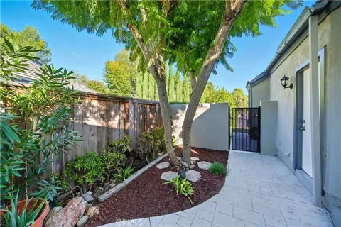 a view of a backyard with plants and a fountain