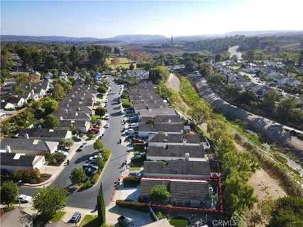 an aerial view of residential houses with outdoor space and parking