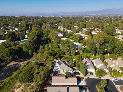 an aerial view of residential houses with outdoor space and trees