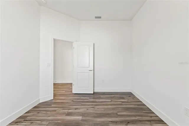 a view of an empty room with wooden floor