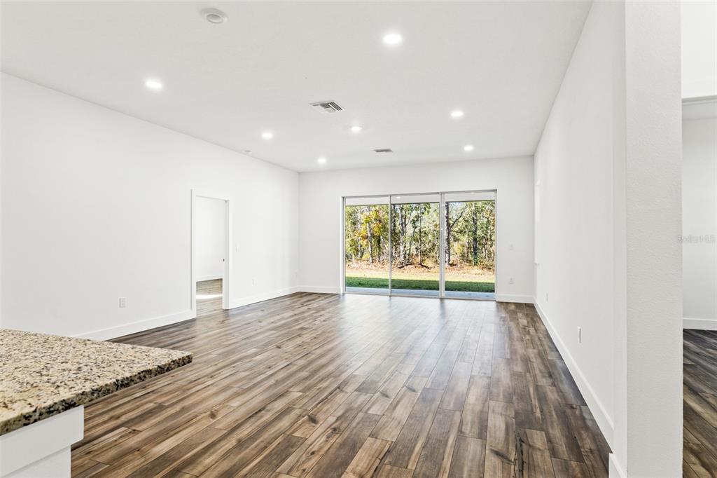 15171 Pomp Parkway Weeki Wachee, FL 34614 - Photo 13 of 50 a view of an empty room with wooden floor and a window