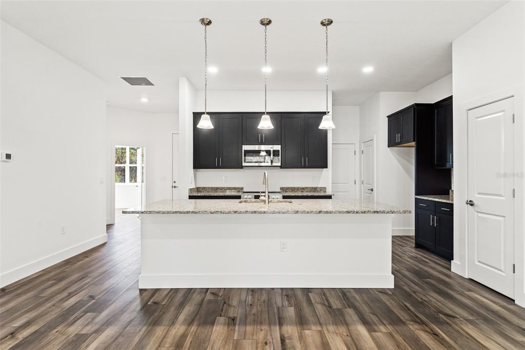 15171 Pomp Parkway Weeki Wachee, FL 34614 - Photo 14 of 50 a large kitchen with stainless steel appliances a large counter top a sink a stove and a refrigerator