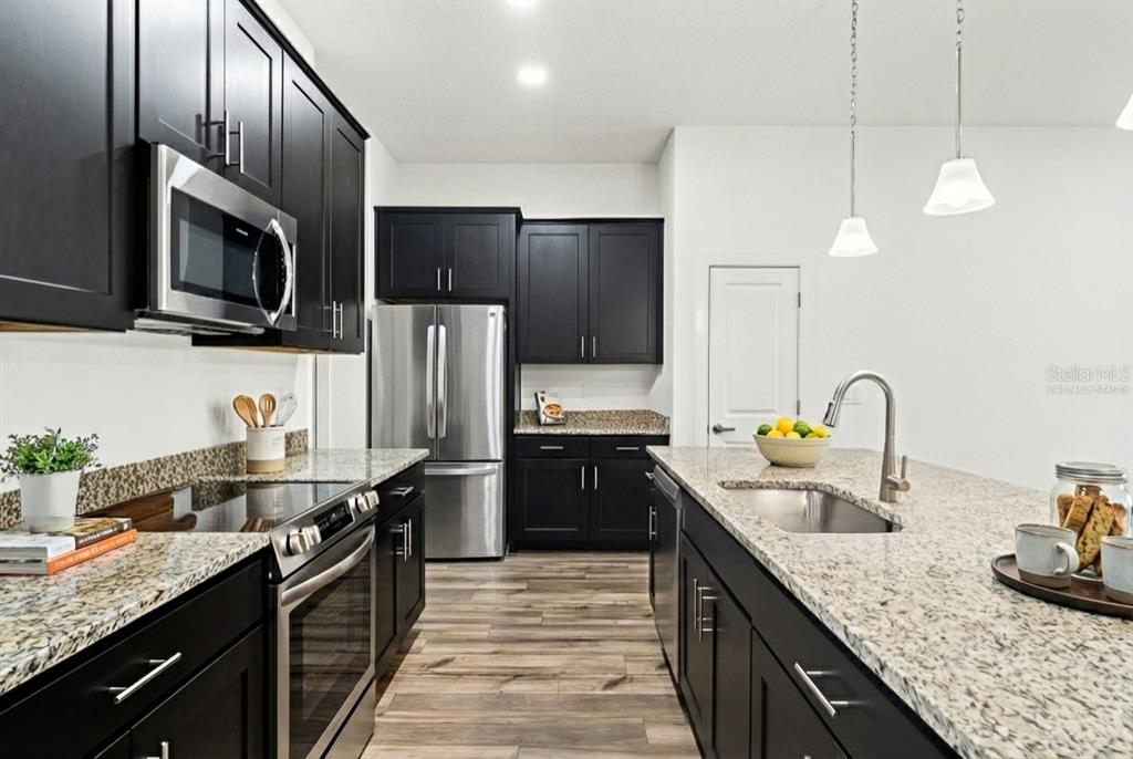 15171 Pomp Parkway Weeki Wachee, FL 34614 - Photo 16 of 50 a kitchen with granite countertop stainless steel appliances and wooden cabinets