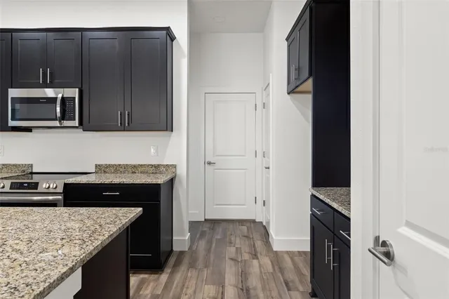 a kitchen with granite countertop stainless steel appliances and wooden cabinets