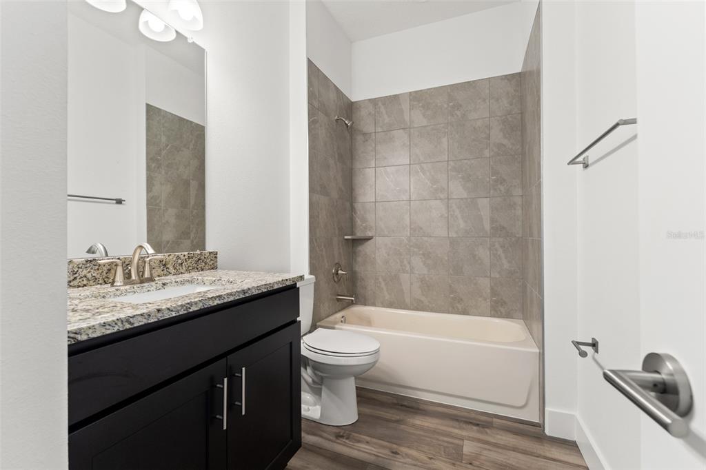 15171 Pomp Parkway Weeki Wachee, FL 34614 - Photo 38 of 50 a bathroom with a granite countertop sink toilet and shower